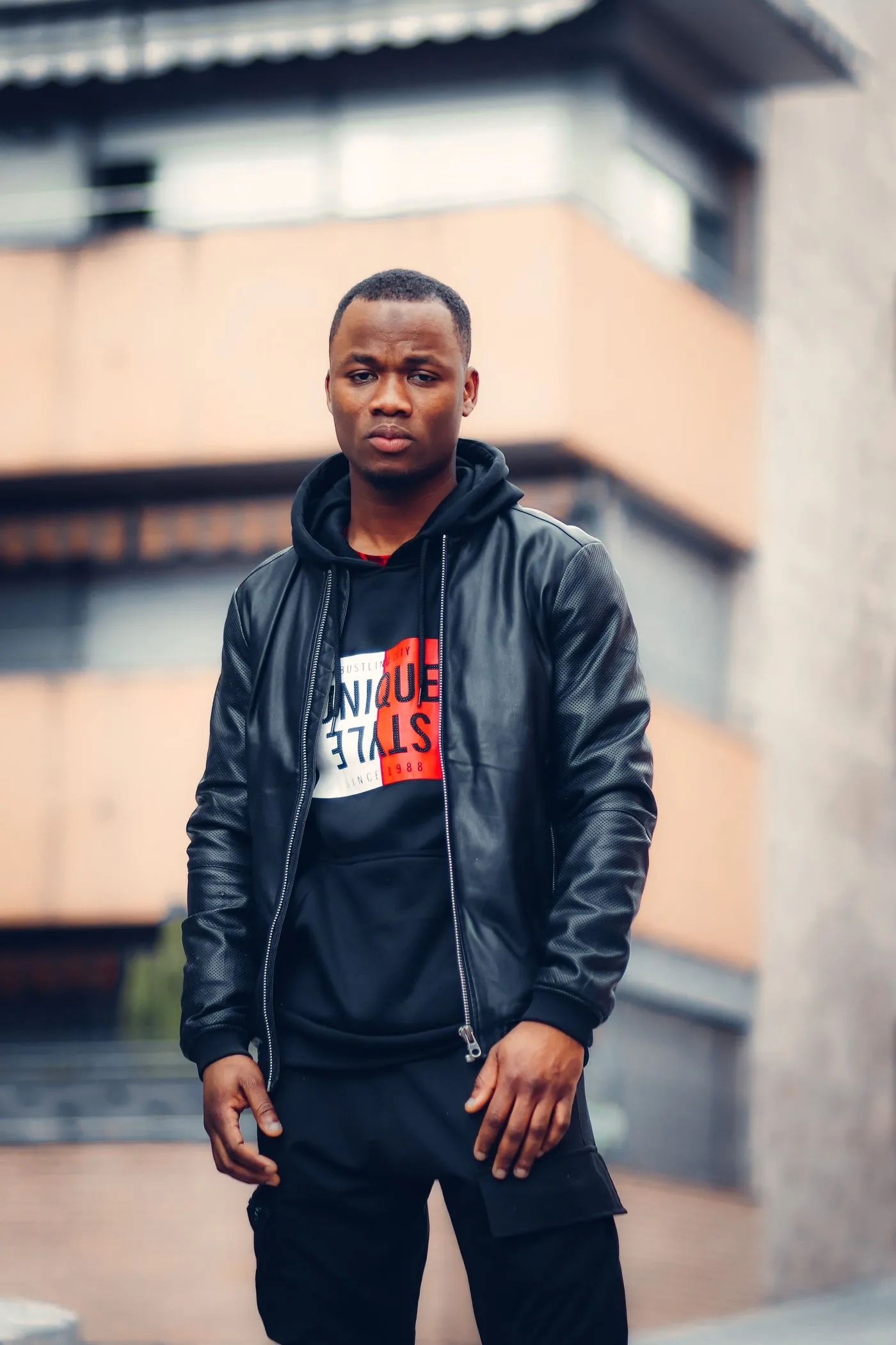 A black jacket worn over a hoodie, showing how an extra layer changes the overall fit